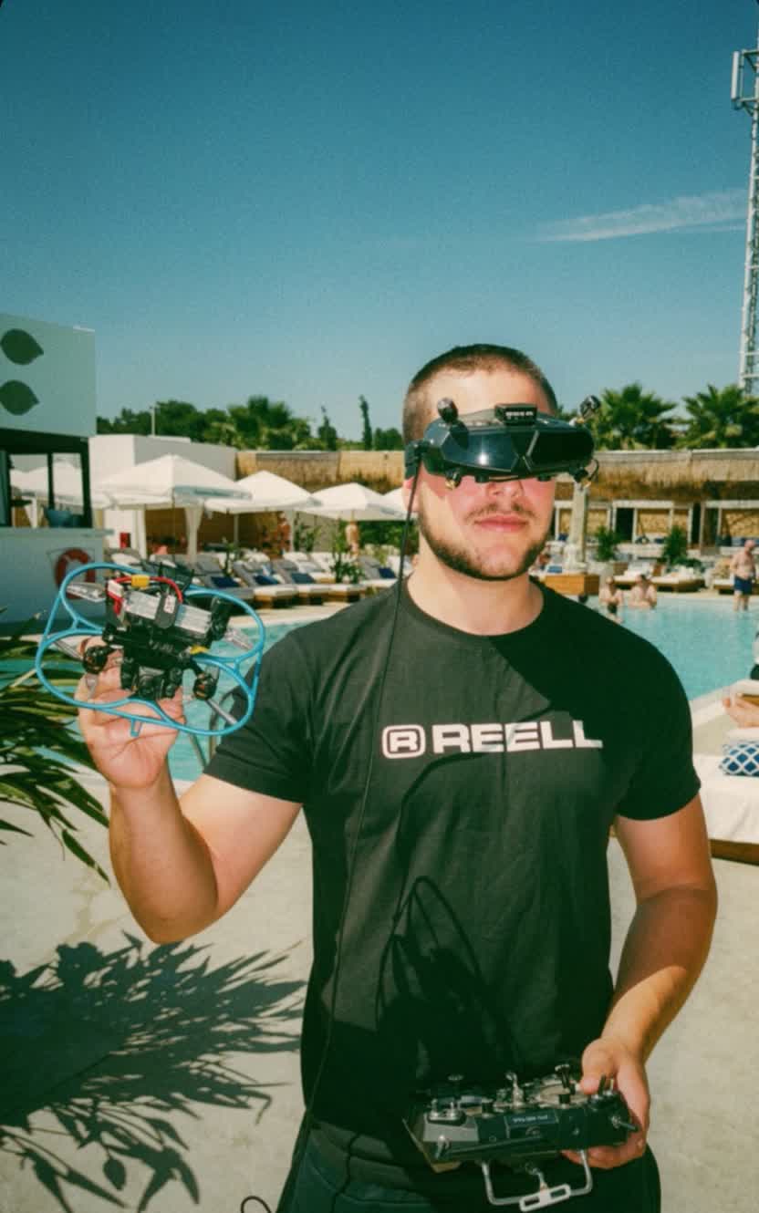 Samuel Riera, piloto de Aeroflow Studio, con gafas FPV sujetando un cinewhoop y la emisora durante un rodaje en exteriores